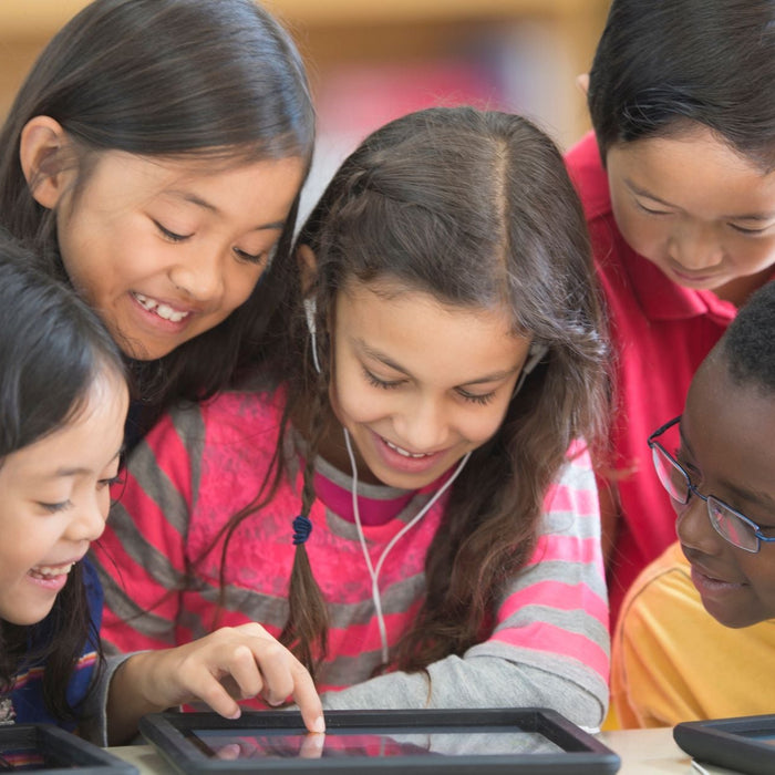 Group of interested students gathered around one tablet