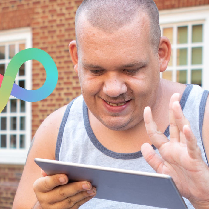 Autistic adult using an AAC device, neurodiversity infinity symbol next to him