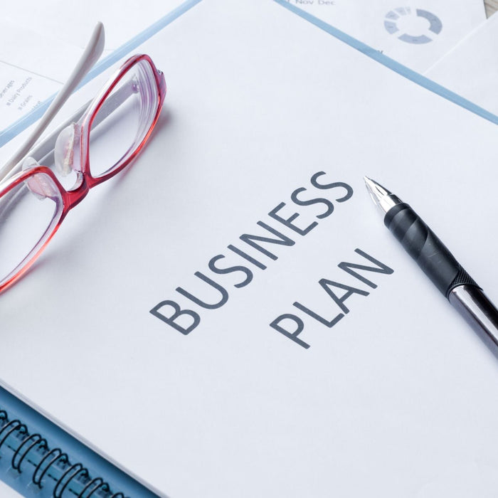 Business plan notebook with pen and glasses