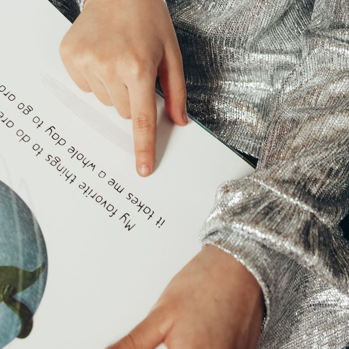 Child reading a social story with images.