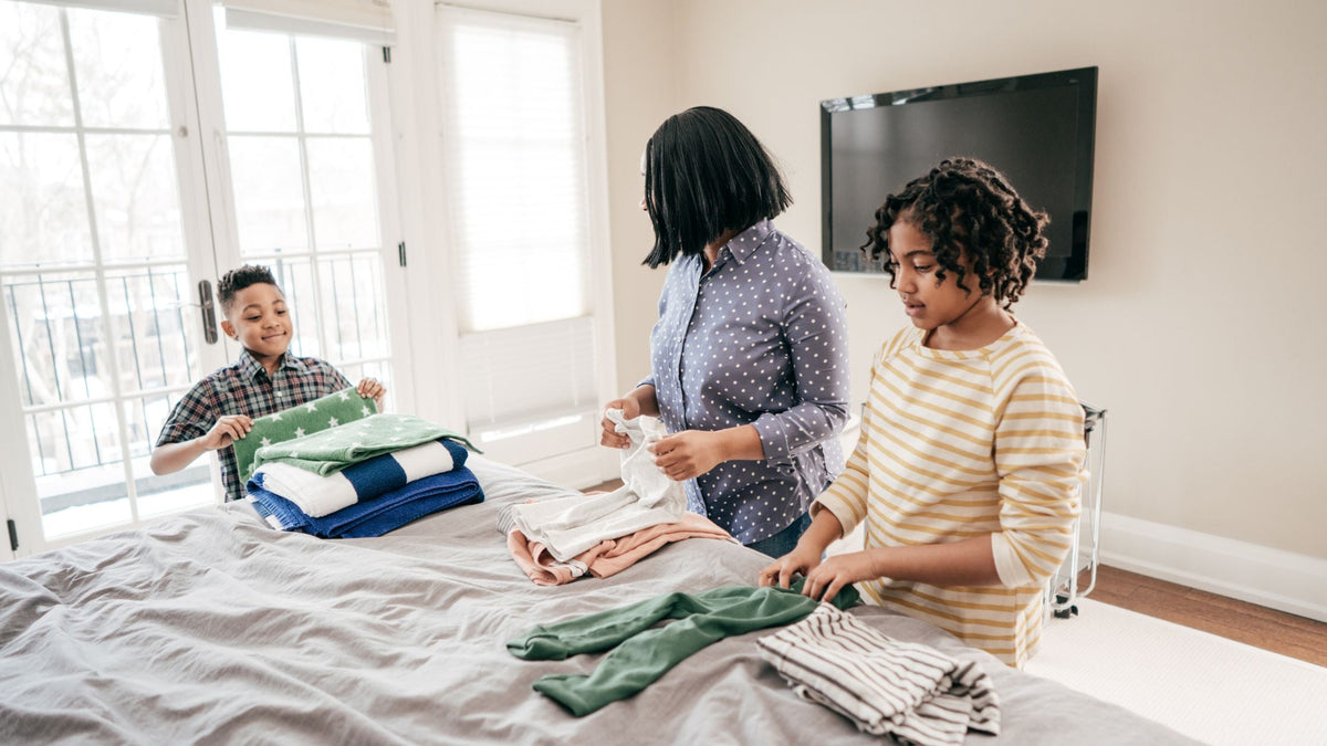 A parent and child working together to fold laundry, illustrating the importance of collaborative learning in teaching household chores.
