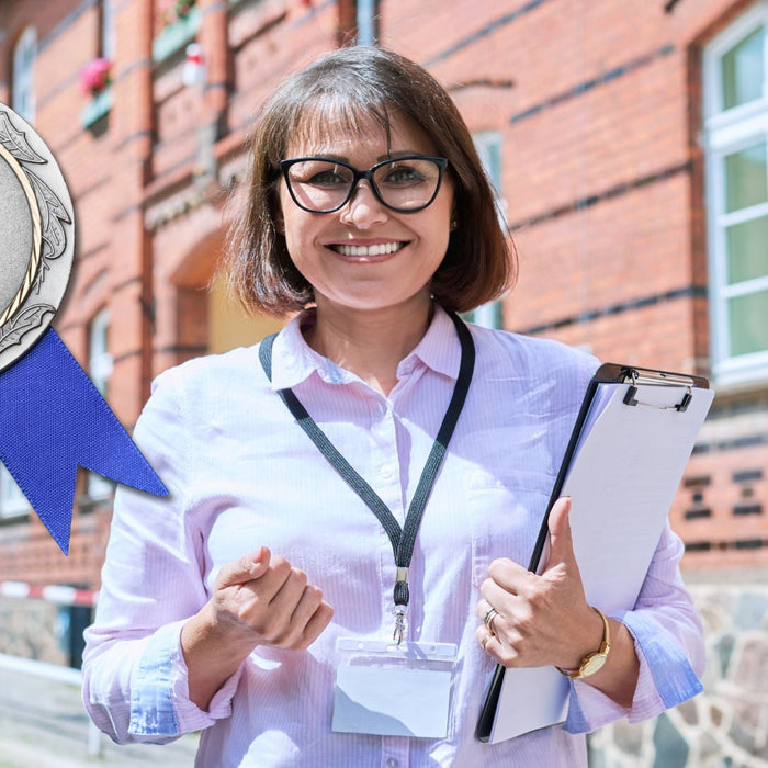 A paraprofessional holding a clipboard next and next to medal.
